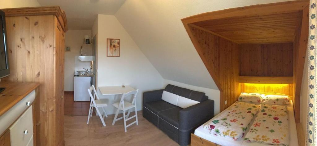 a small bedroom with a bed and a chair at zum Aal in Wester-Ohrstedt
