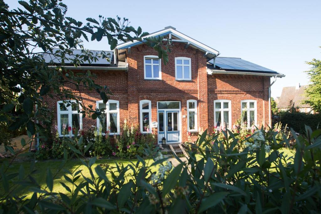 une maison en briques avec des fleurs devant elle dans l'établissement BoJe, à Waabs