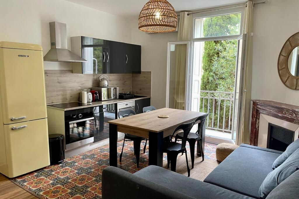 a living room with a table and a kitchen at Appartements Rue des Jardins in Perpignan