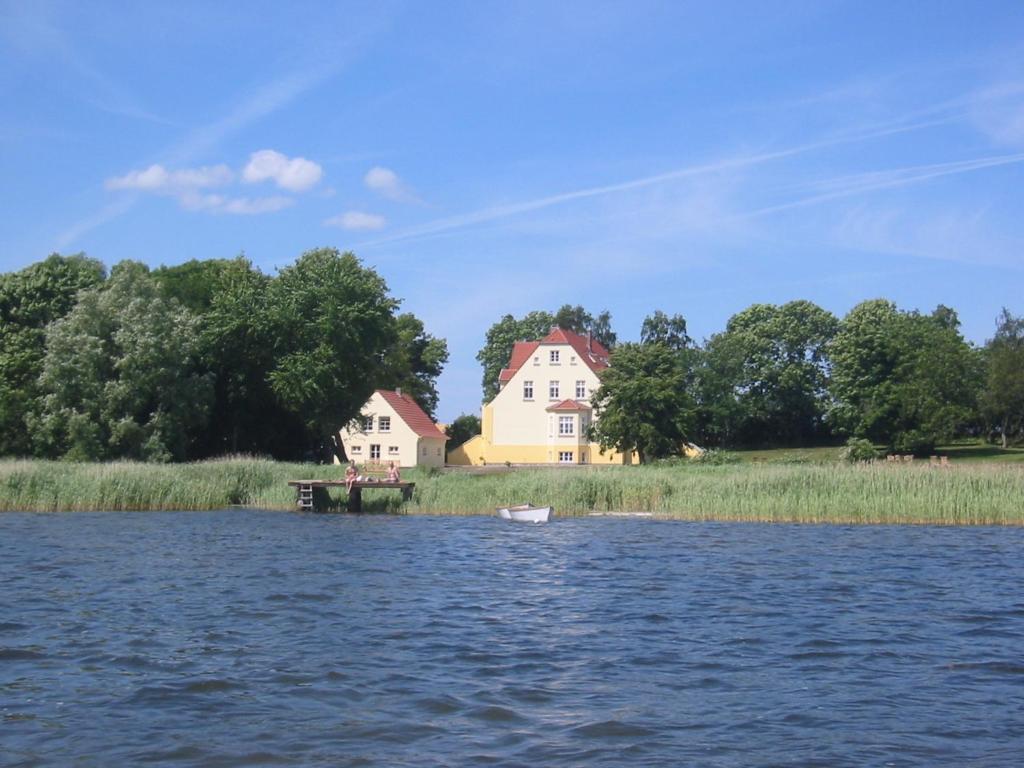 ein Haus am Ufer eines Wasserkörpers in der Unterkunft Ferienwohnung 6 WLAN Sauna Wasserblick in Neuenkirchen