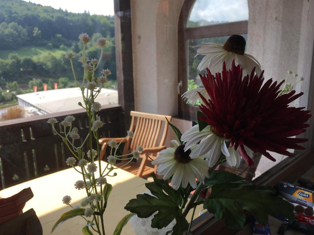 a vase of flowers sitting on a table with a window at Lina's Rhön in Bad Brückenau