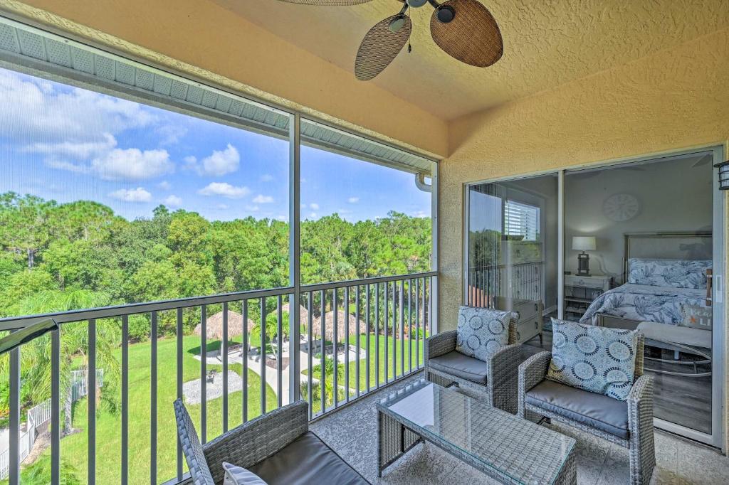 Cette chambre dispose d'un balcon avec un lit et des chaises. dans l'établissement Luxe Top-Floor Condo in Beautiful Lely Resort, à Old Marco Junction