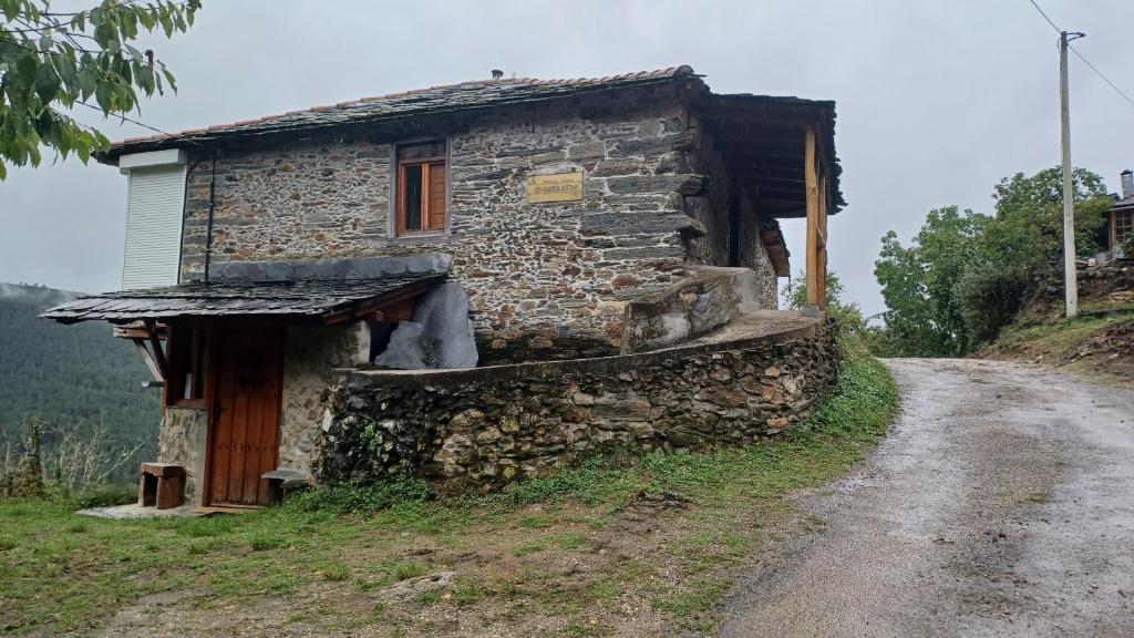 una vieja casa de piedra en un camino de tierra en A Palleira en Castro Caldelas