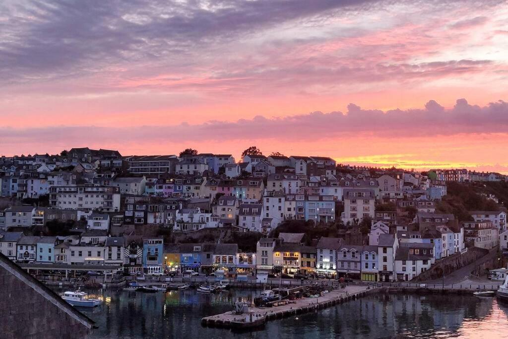 a view of a city with a harbor at sunset at Luxury dog friendly home in Brixham harbour with sea views and free parking in Brixham