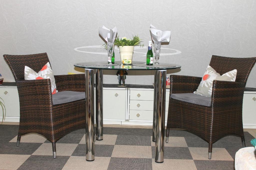 グレーミッツにあるFerienwohnung Ahlvers - gemütliches Feriennest für Zweiのテーブル(椅子付)、テーブル(ワイン1本付)