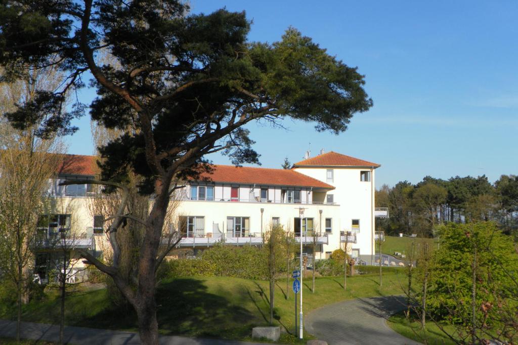 a large white building with a tree in front of it at Ostsee-Residenz Whg 12 in Zingst