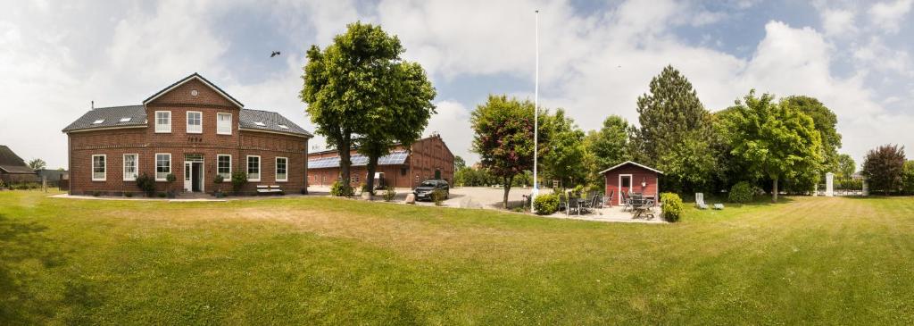 a large brick house in a field of green grass at Wohnung 1 in Fehmarn