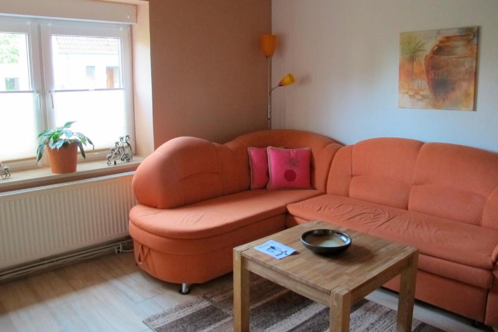 a living room with an orange couch and a table at Thiesen in Kochendorf