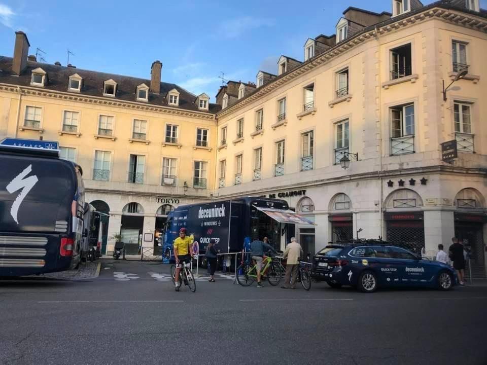 un groupe de personnes voyageant en vélo dans une rue avec un bus dans l'établissement Hotel De Gramont, à Pau