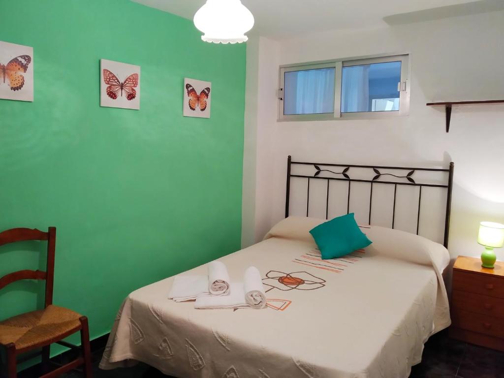 1 dormitorio con 1 cama con mariposas en la pared en Casa Rural Celia, en Ayna