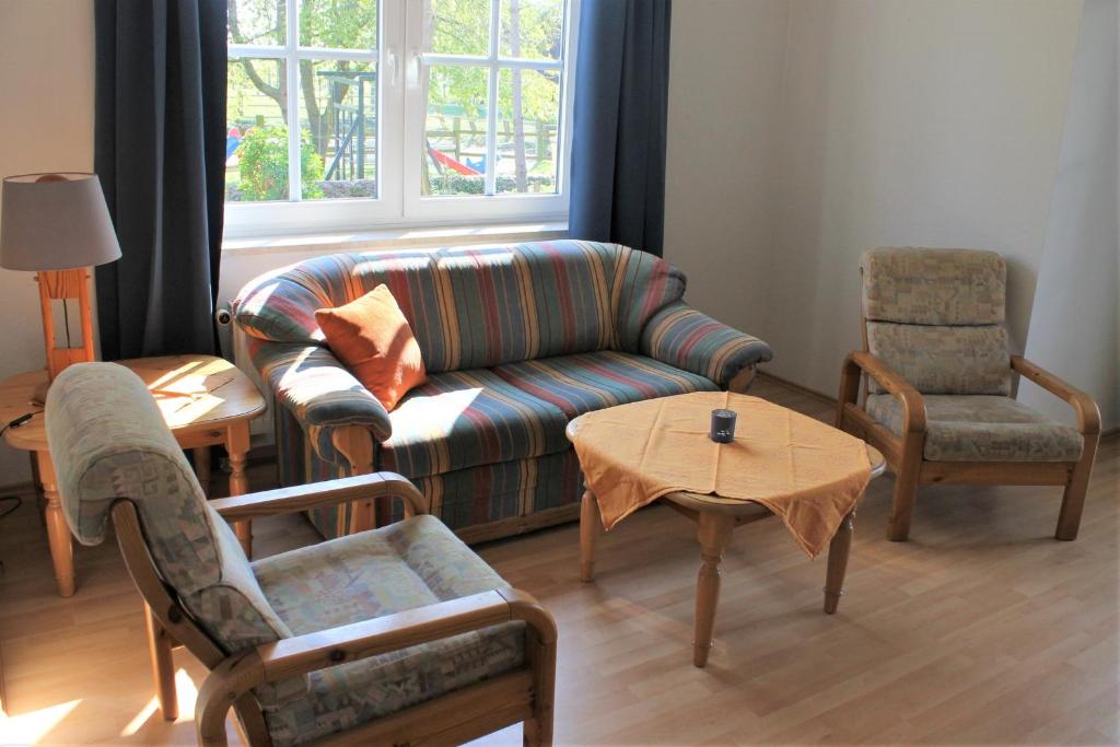 sala de estar con sofá, 2 sillas y mesa en "Pappelhof - Whg 1" en Grömitz