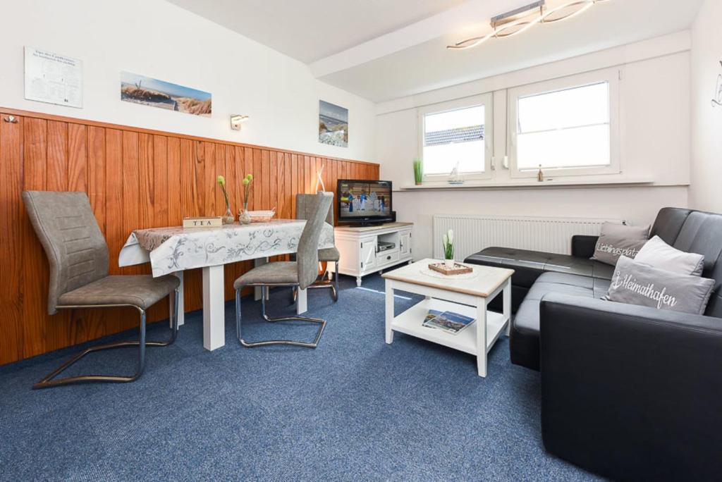 sala de estar con sofá y mesa en Ferienwohnung Haus Boje "Knurrhahn", en Neuharlingersiel