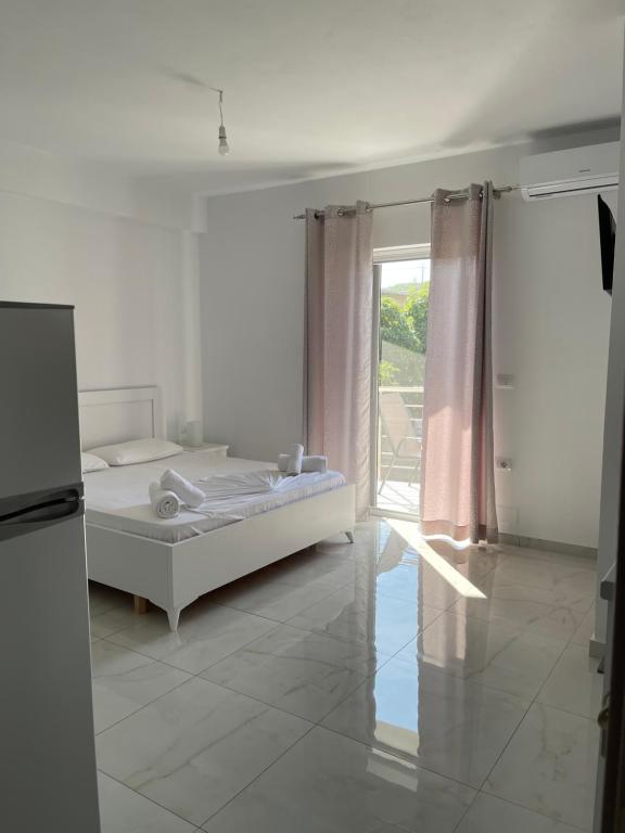 a white room with a bed and a window at Villa Angelina Ksamil in Ksamil