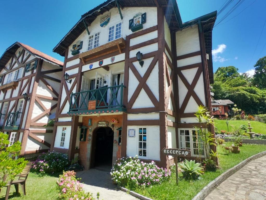 una casa en medio de un campo verde en Nova Pousada Chamonix en Teresópolis