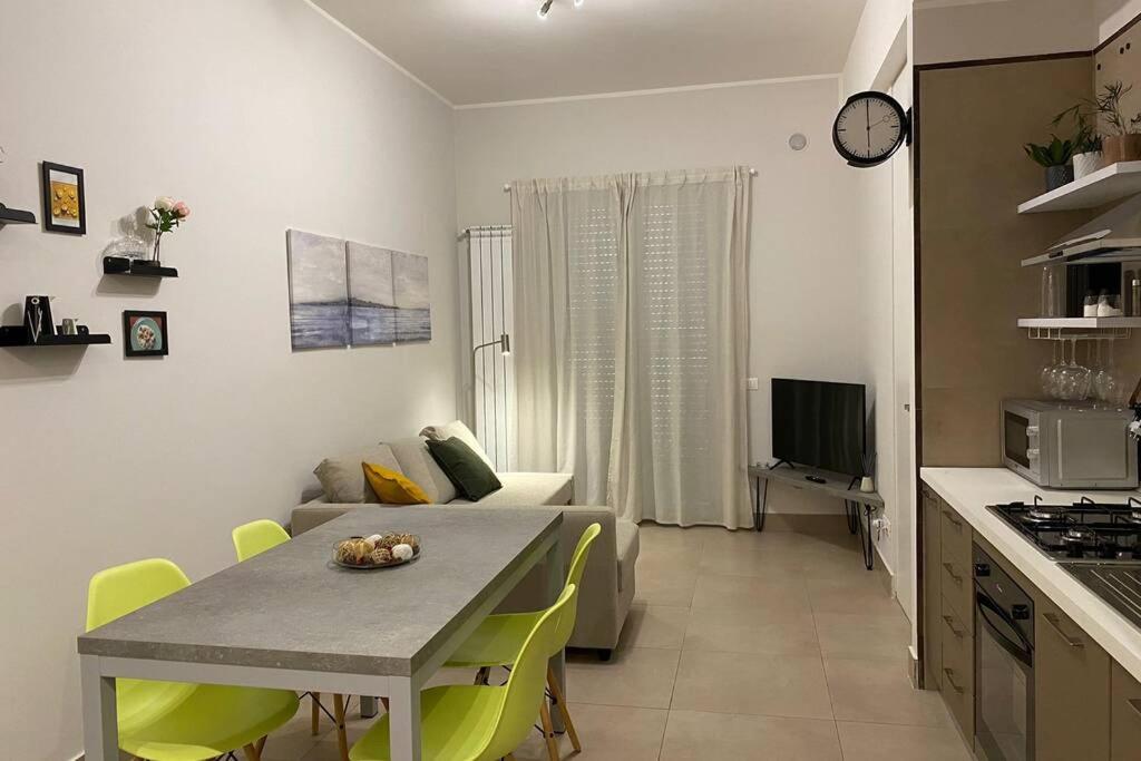 a kitchen and living room with a table and a couch at B&B Piano1 Interno5 - Accogliente e moderno bilocale vicino al centro in Salerno