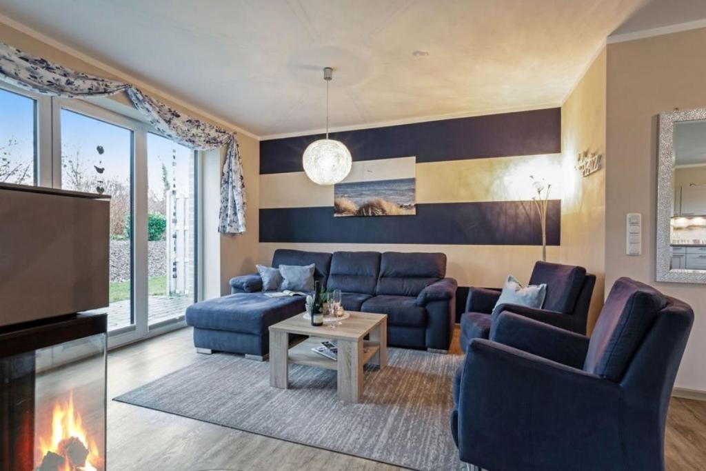 sala de estar con sofás azules y TV en Wellness - Ferienhaus Steilküste, en Klausdorf