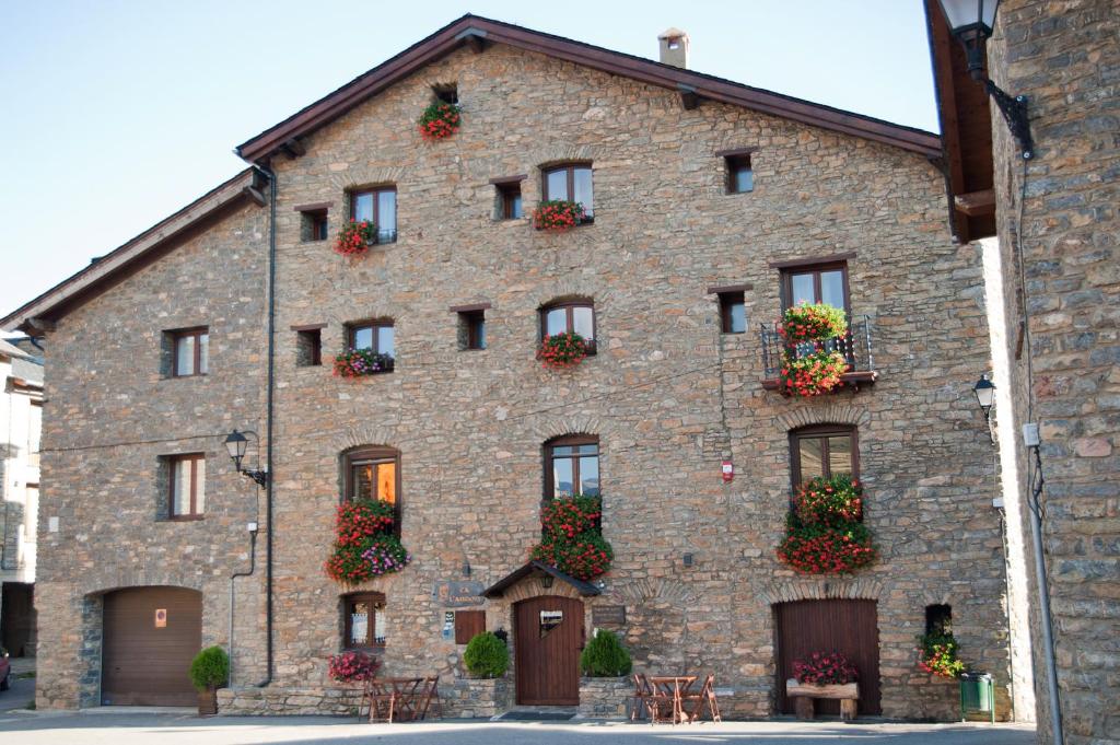 a large brick building with flower boxes on it at Allotjament Rural Ca L'Anton in Pujal