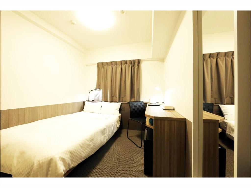 a hotel room with two beds and a desk at Sendai Business Hotel Ekimae - Vacation STAY 71912v in Sendai