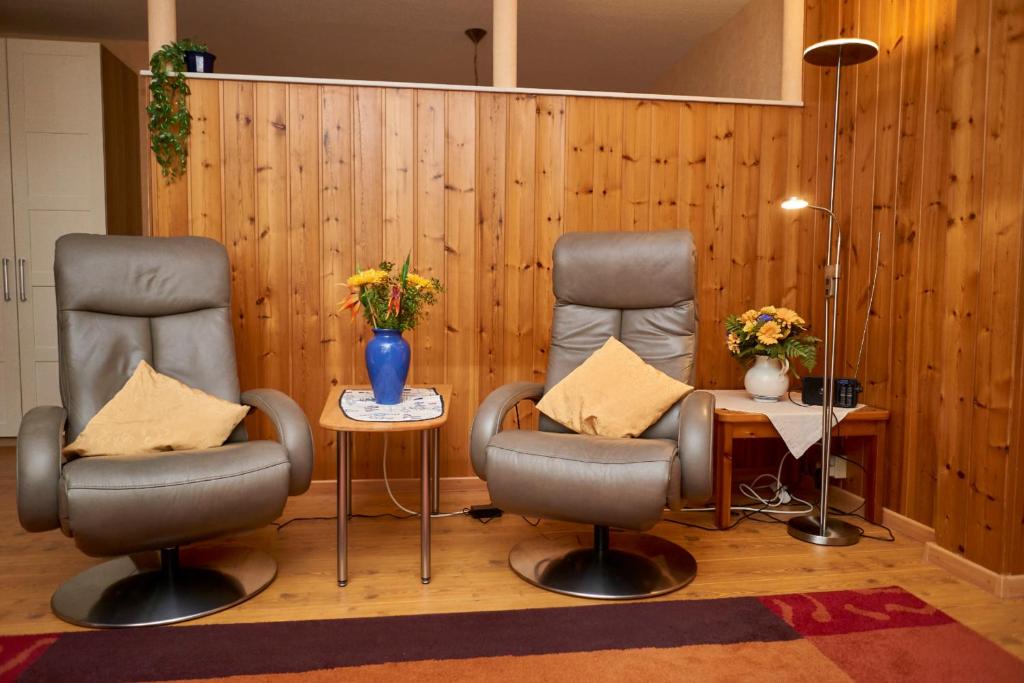 ヴァンガーオーゲにあるOsterdüne 66の椅子2脚とテーブル付きの待合室