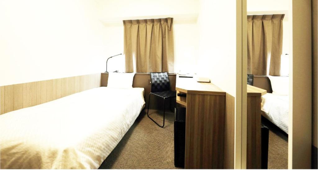 Cette chambre comprend un lit et un bureau. dans l'établissement Sendai Business Hotel Ekimae - Vacation STAY 71907v, à Sendai