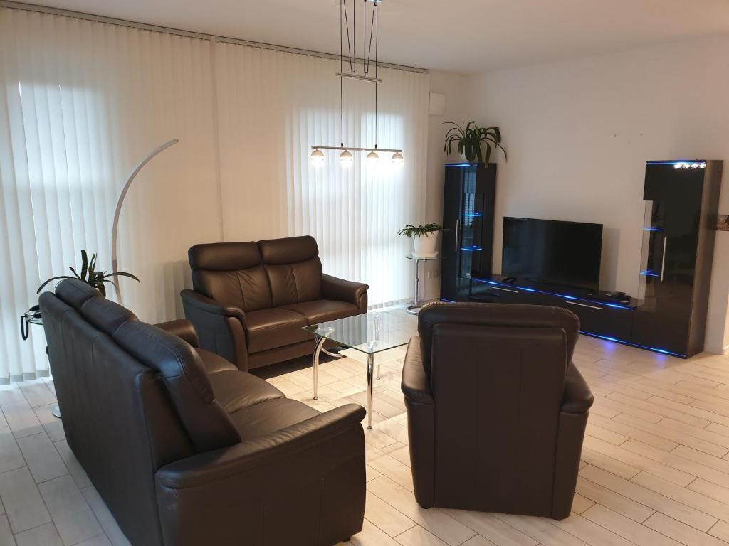 een woonkamer met 2 stoelen en een televisie bij Ferienwohnung Reinhardt in Oldenburg