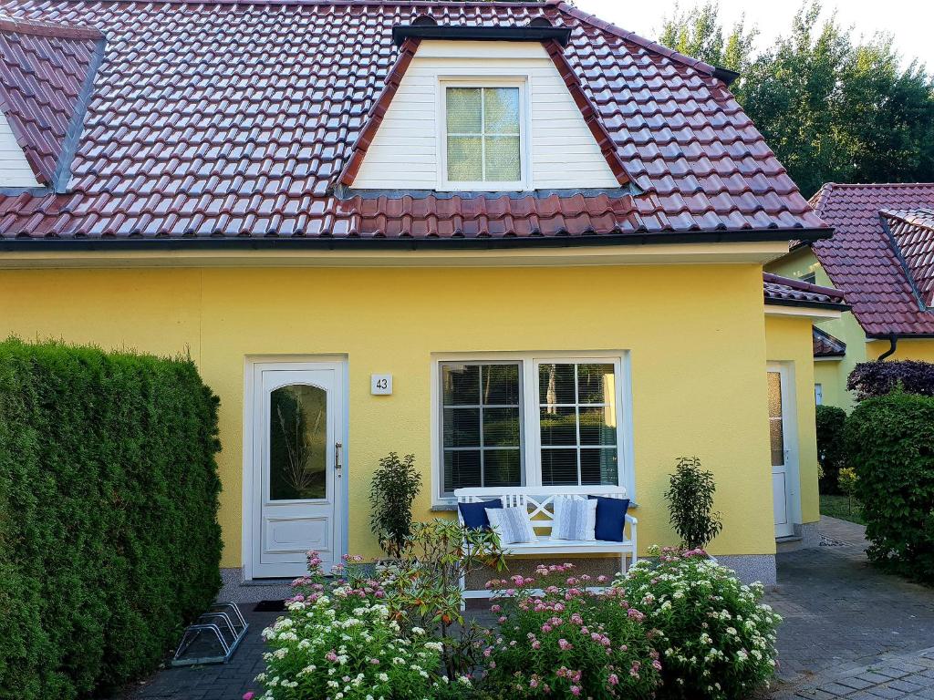 a yellow house with a red roof at Am Deich 43 in Zingst