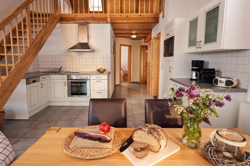 een keuken en eetkamer met een tafel met brood en bloemen bij Ferienhof Wuchner - Fewo "Wintertraum" in Fröhnd