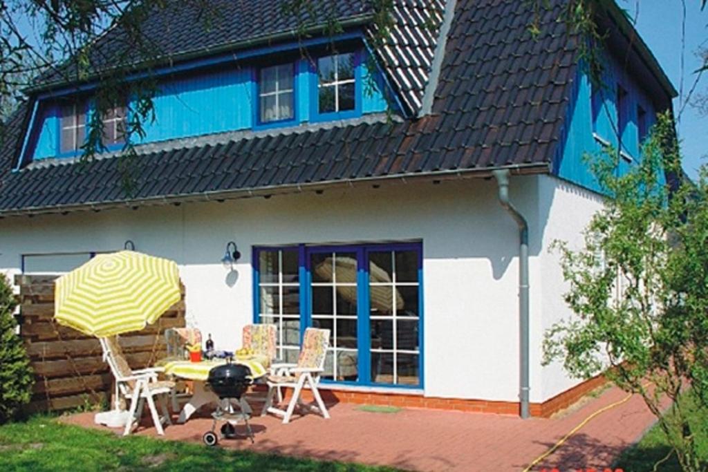 een huis met een tafel en stoelen en een grill bij Strandläufer - 21841 in Zingst