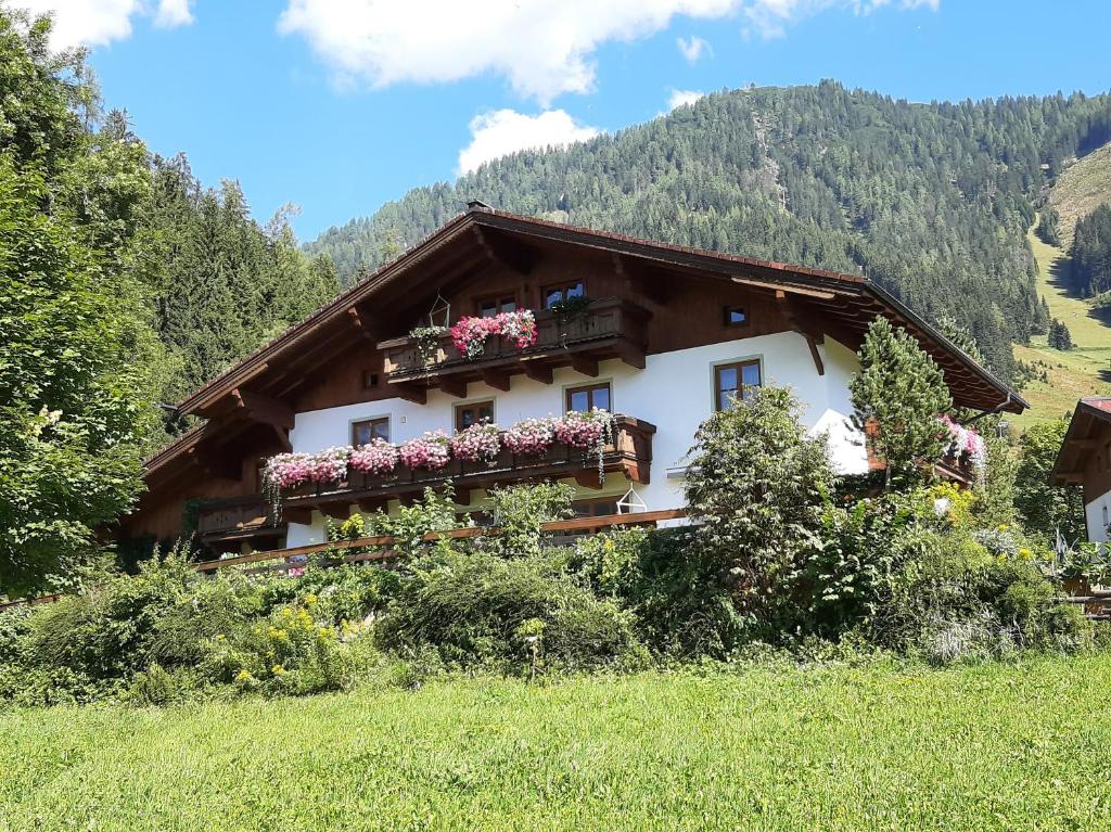 a house in the mountains with flowers on the balconies at Appartement Vierthaler in Werfenweng