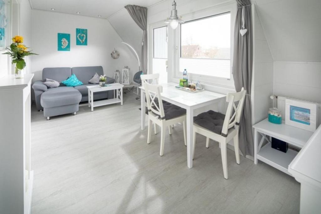 uma cozinha e sala de estar com mesa e cadeiras em Skippers Cabin em Norddeich