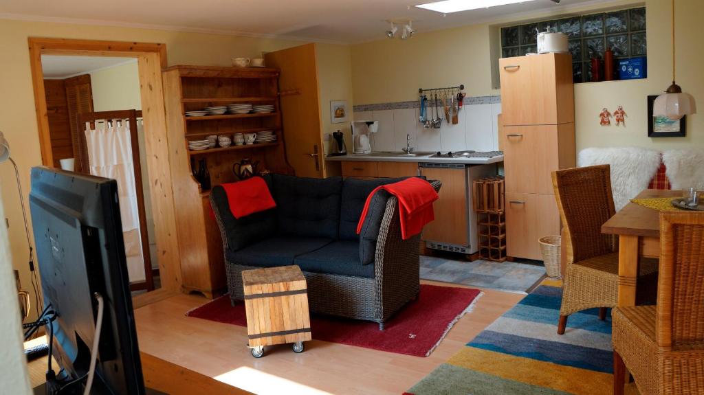 sala de estar con silla y cocina en Rücker, en Eckernförde
