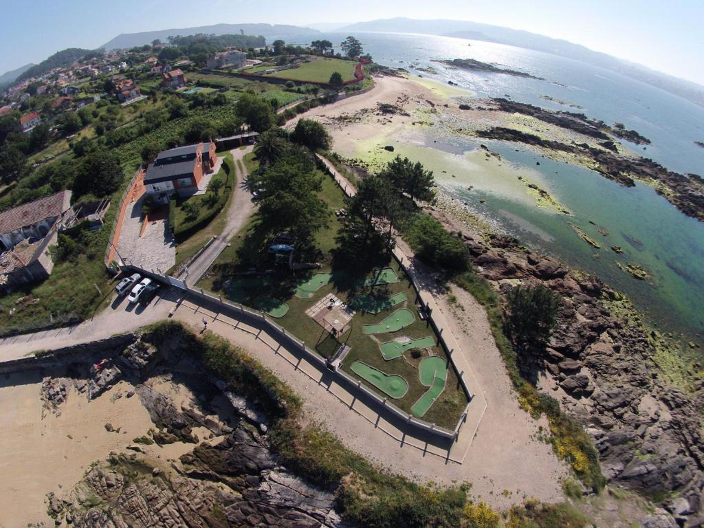 an aerial view of a golf course next to the ocean at La Garita Casa Rural in Cangas de Morrazo