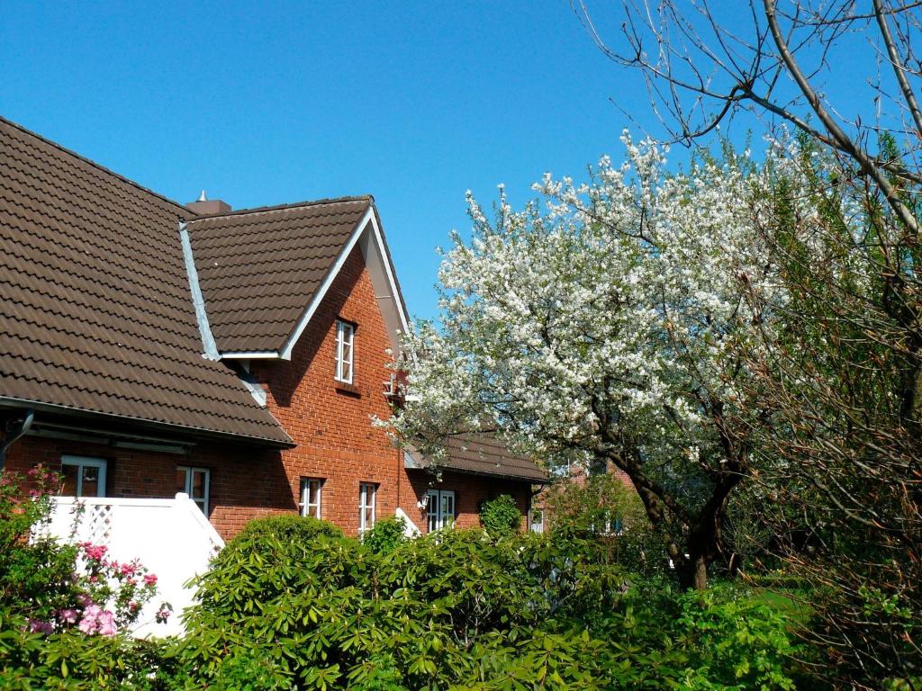 ein Haus mit einem blühenden Baum davor in der Unterkunft Ferienwohnung "Seidler" in Rendsburg