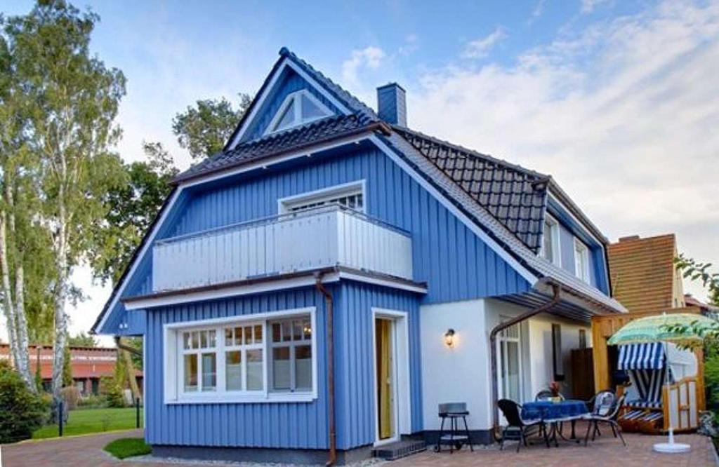 a blue and white house with a table and chairs at Kinnekulle 2 in Zingst