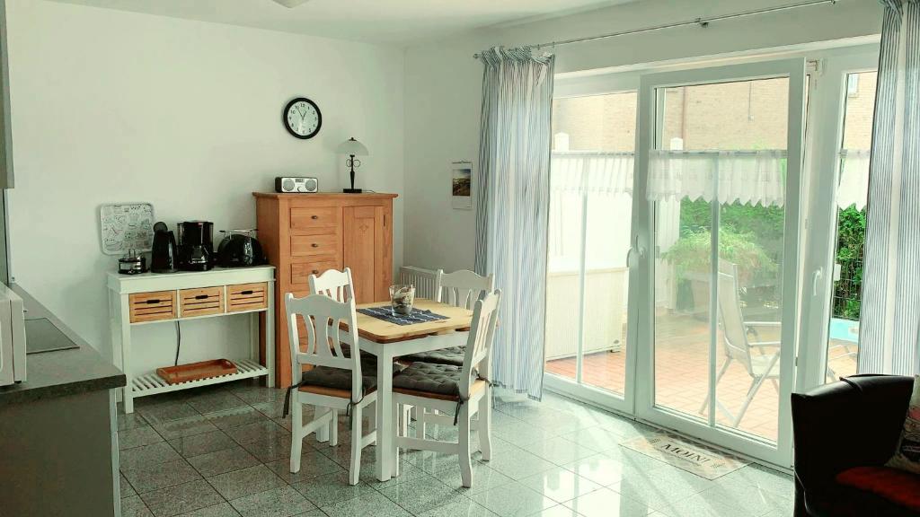 a kitchen with a table and chairs and a dining room at Ferienwohnungen Saida Wohnung 3 in Norden