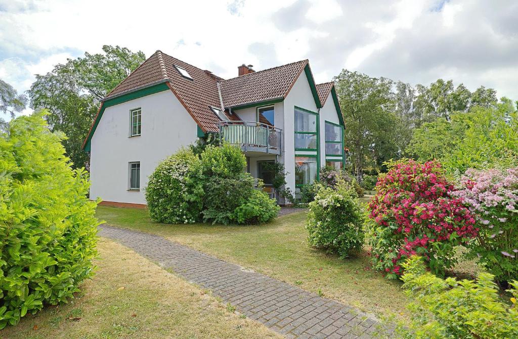 a large white house with a balcony and flowers at Vierkant FW 2 in Zingst