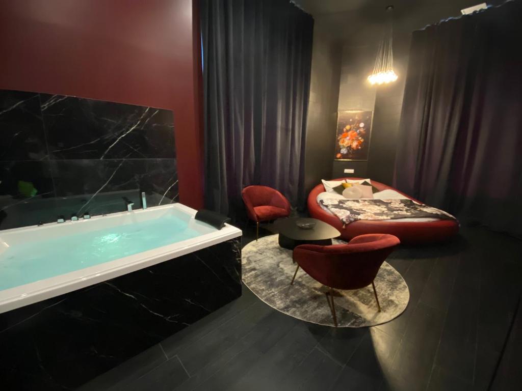 un bagno con vasca e una camera con letto di Legend Majestic Superbe Love Room - Jacuzzi - Champagne - Romantisme - parking privé a Mâcon