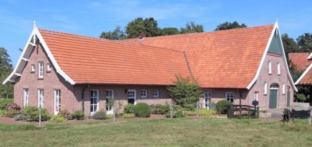 una gran casa de ladrillo con techo naranja en Naturhof Buschwiesen - Wohnung Lama, en Wilsum