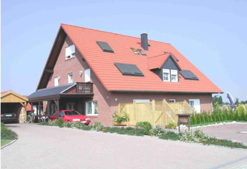 a large house with a red roof with solar panels on it at Fehmarn-OstseeferienFewoAnders31593 in Neue Tiefe Fehmarn