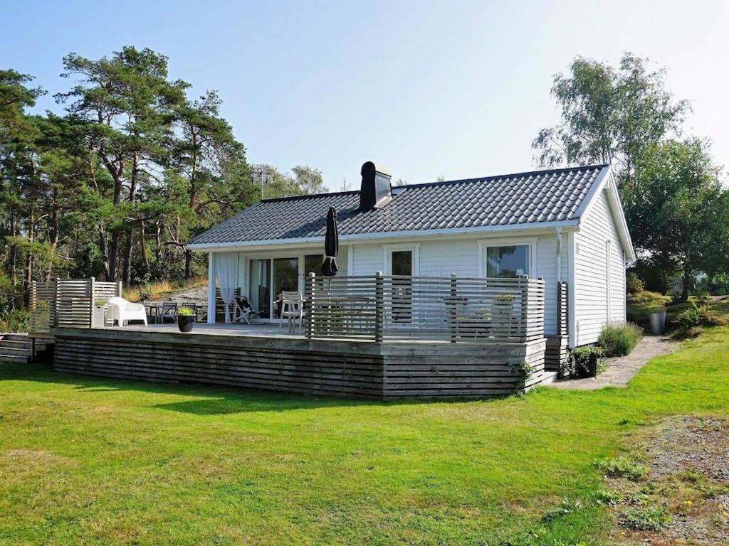 a small white house with a large deck at 5 person holiday home in V r backa in Väröbacka
