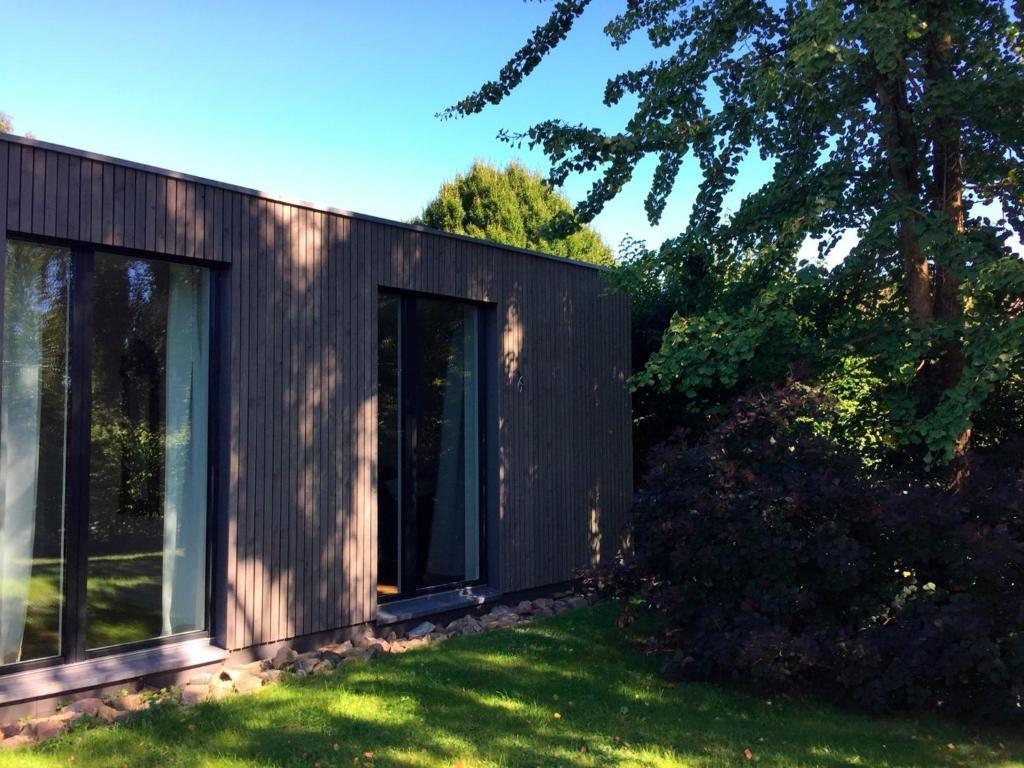 een zwart huis met glazen deuren in een tuin bij Ferienhaus HL 23 in Eckernförde