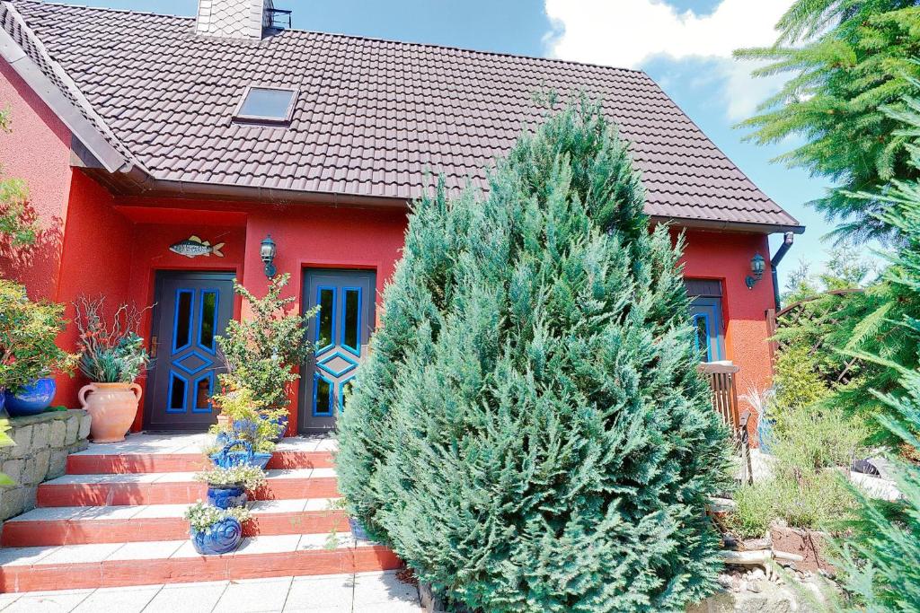 una casa rossa con due alberi di Natale davanti di Hoffmann, Uwe - 21690 a Zingst