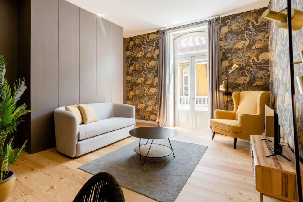 een woonkamer met een bank en een tafel en stoelen bij BOUTIQUE Rentals-Art & Charm II Apt w/ Terrace in Porto