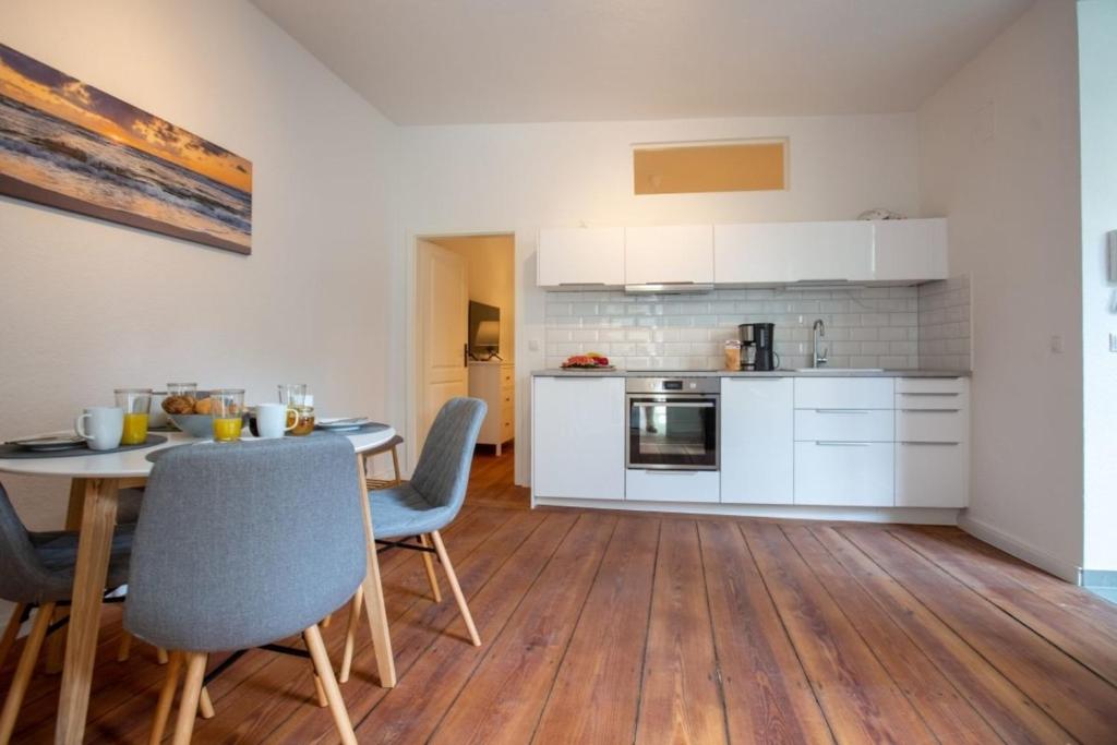 施特拉爾松德的住宿－Apartment No2，厨房以及带桌椅的用餐室。