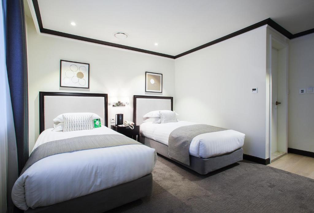 Postel nebo postele na pokoji v ubytování The Grand Hotel Myeongdong
