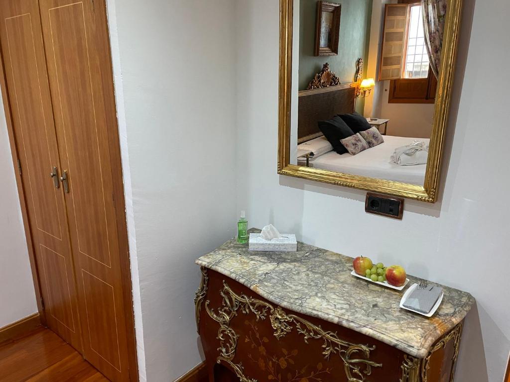 a room with a mirror and a table with fruit on it at La Llave de la Judería Hotel Boutique in Córdoba