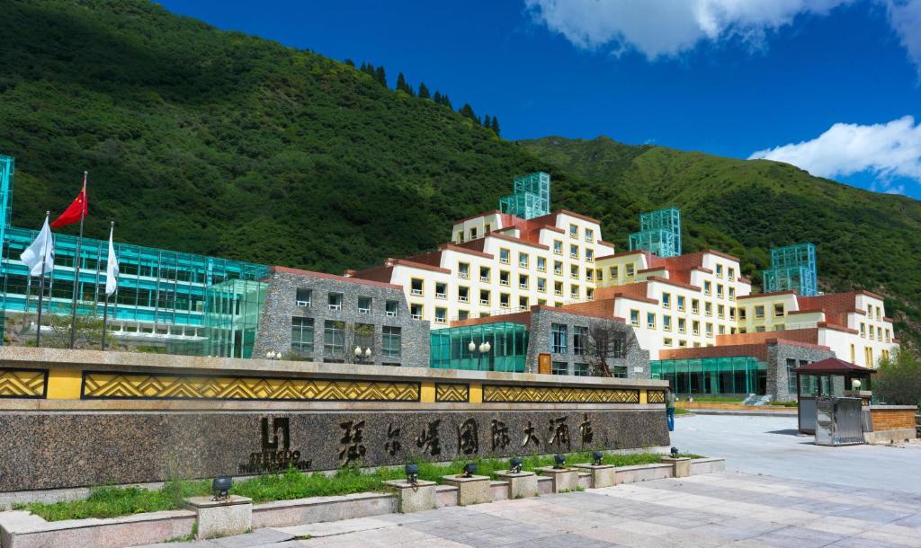 a group of buildings in front of a mountain at Seercuo International Hotel in Songpan