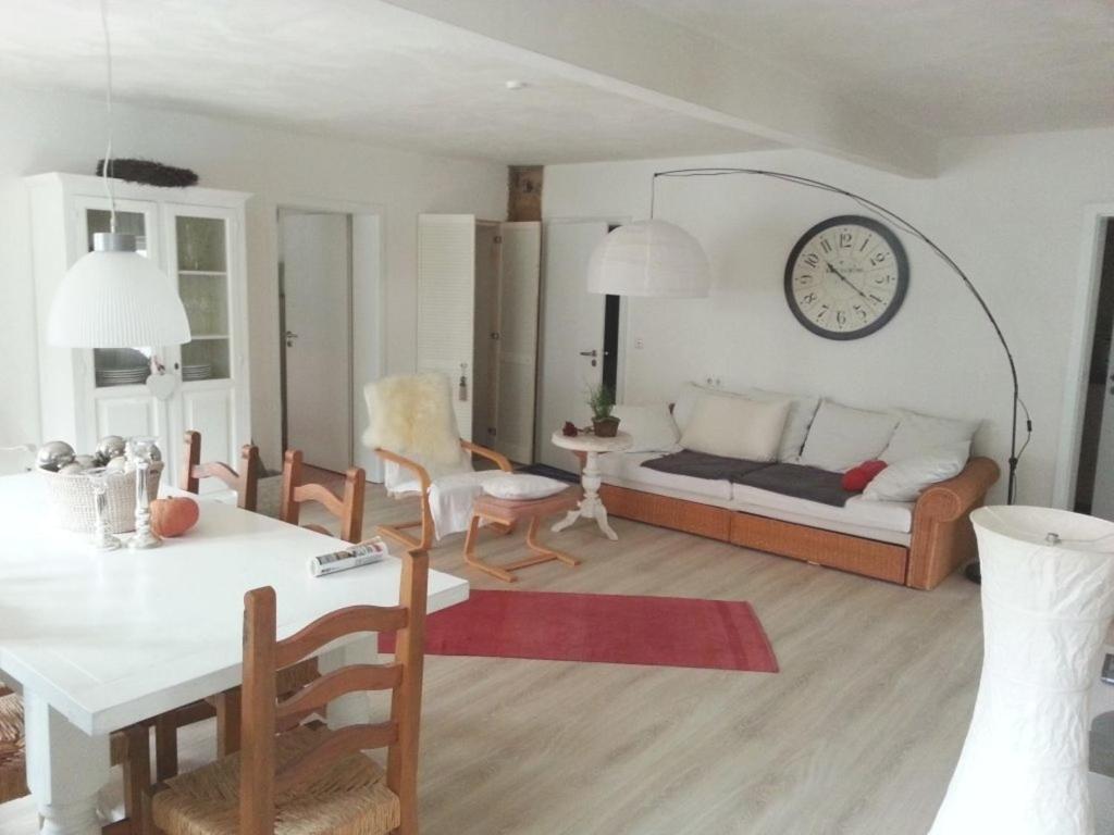 a living room with a couch and a clock on the wall at Ferienwohnung SineFinibus in Bad Grönenbach