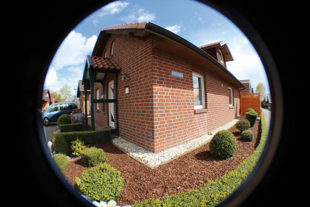 a brick house with a round window in front of it at Ferienhaus Eiklenborg "Am Heeder See" in Heede