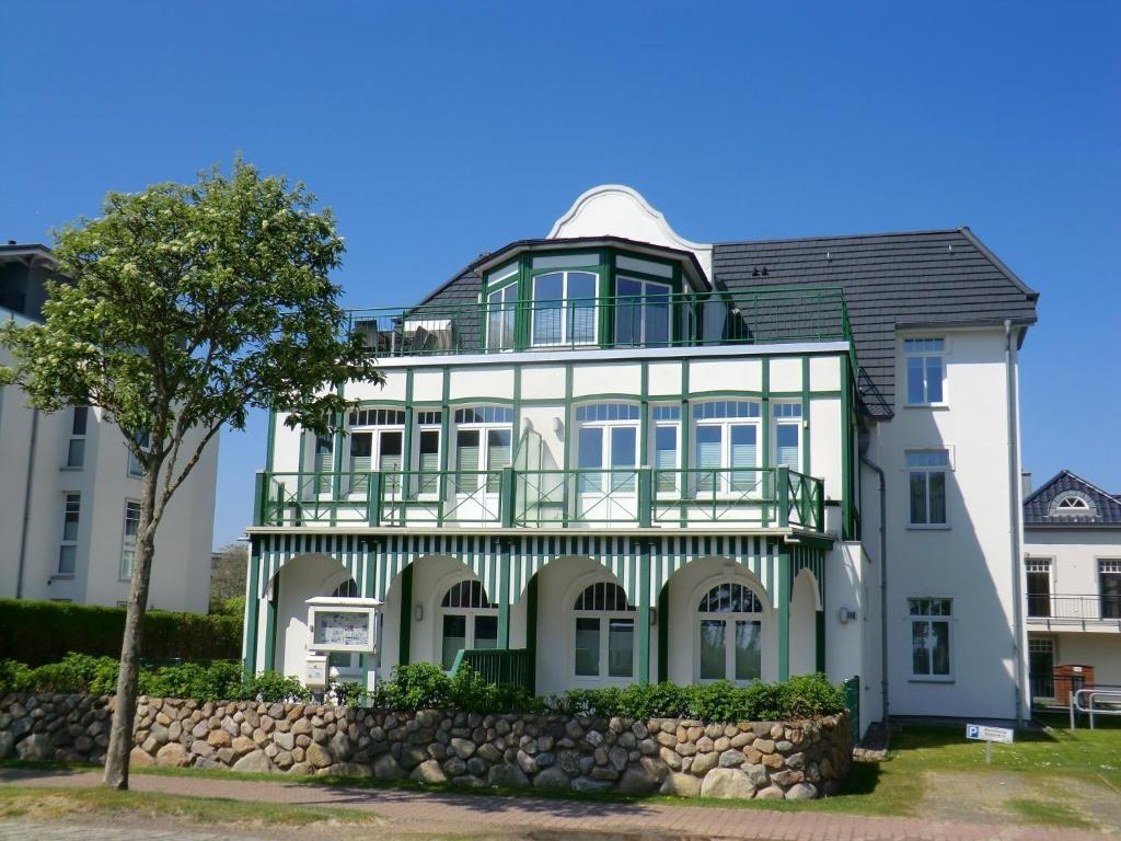 uma grande casa branca com uma varanda em Luxus-Penthouse am Strand, mit Traum-Meerblick, Dachterrasse und Sauna em Wyk auf Föhr